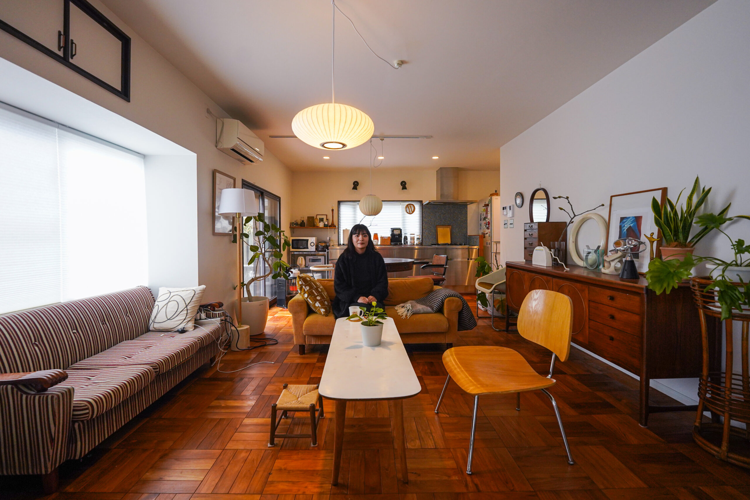 ストライプのレトロソファと大きな窓が特徴のリビング、奈良 Vintage Garden の家具に囲まれ自然光が差し込む空間
